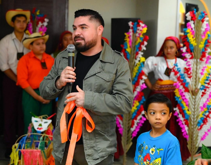 Fotografía de la inauguración de la nueva Zona Bitcoin que muestra al director de TejidoSocialSV Carlos Marroquín junto a un infante y otras personas.